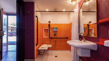 A modern bathroom with a walk-in shower, a white sink, and a large mirror.
