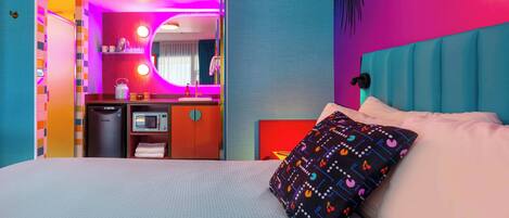 Une chambre d’hôtel équipée d’un lit, d’un four à micro-ondes, d’un lavabo et d’un miroir.
