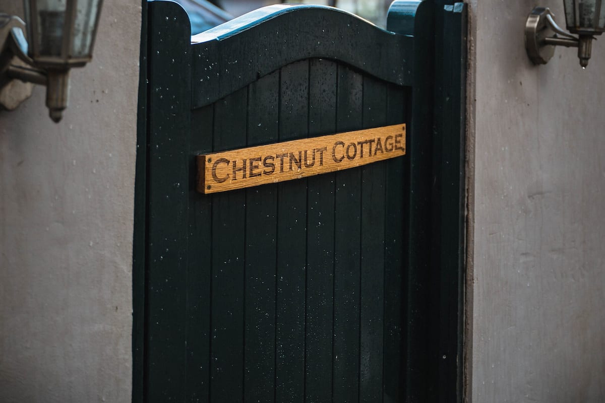 A gated entrance with a sign reading "Chestnut Cottage."
