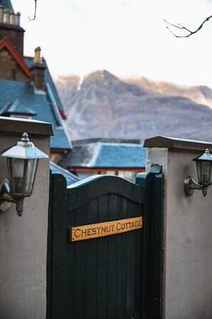 A gated entrance with a sign reading "Chestnut Cottage."