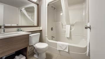 A bathroom with a toilet, sink, mirror, and a bathtub with a shower curtain.