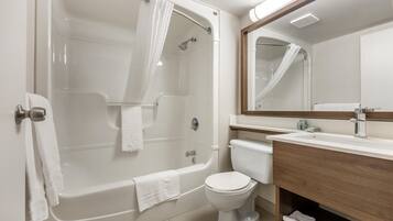 Une salle de bain moderne équipée d’une baignoire, de toilettes et d’un meuble-lavabo avec un miroir.