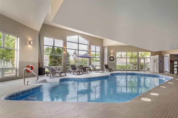 Una piscina cubierta, tumbonas