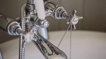A close-up of a bathroom faucet with a "COLD" label and a chain.