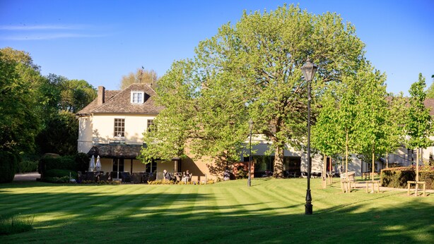 A large, two-story building with a well-maintained lawn and several outdoor seating areas. - Sudbury House Hotel (Faringdon)