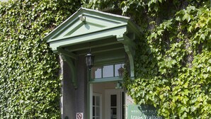A reception area with a green entrance, a sign for Izaak Walton Hotel, and a no-smoking sign. - The Izaak Walton Hotel (Ashbourne)