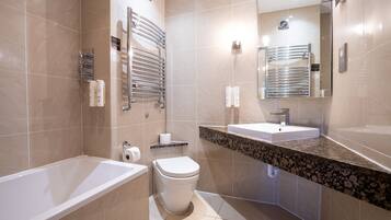 Un baño moderno con bañera, inodoro y lavamanos.