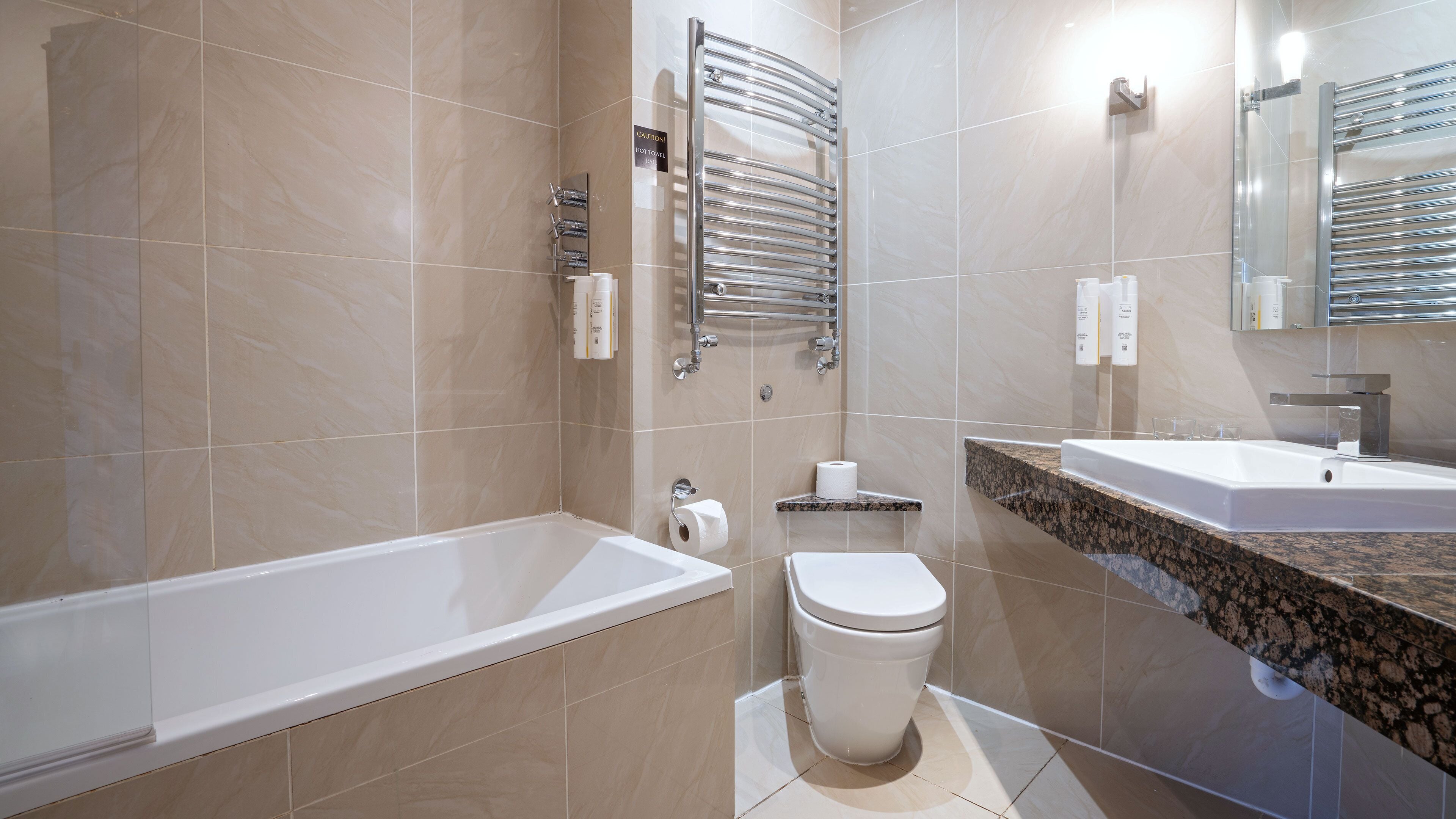 A modern bathroom with a bathtub, toilet, and sink.