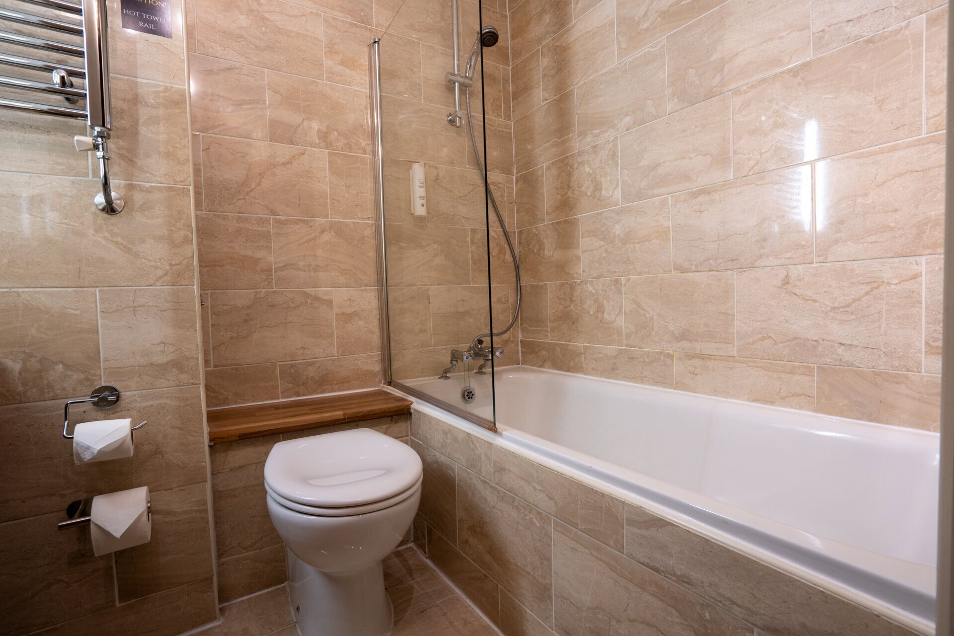 Une salle de bain avec une baignoire, des toilettes et un porte-serviettes.