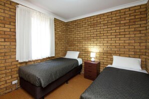 Minibar, tabla de planchar con plancha, ropa de cama y despertador