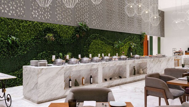 A modern restaurant with a marble counter, green wall, and hanging lights.