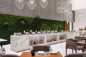 En moderne restaurant med en marmordisk, grøn væg og hængende lamper.