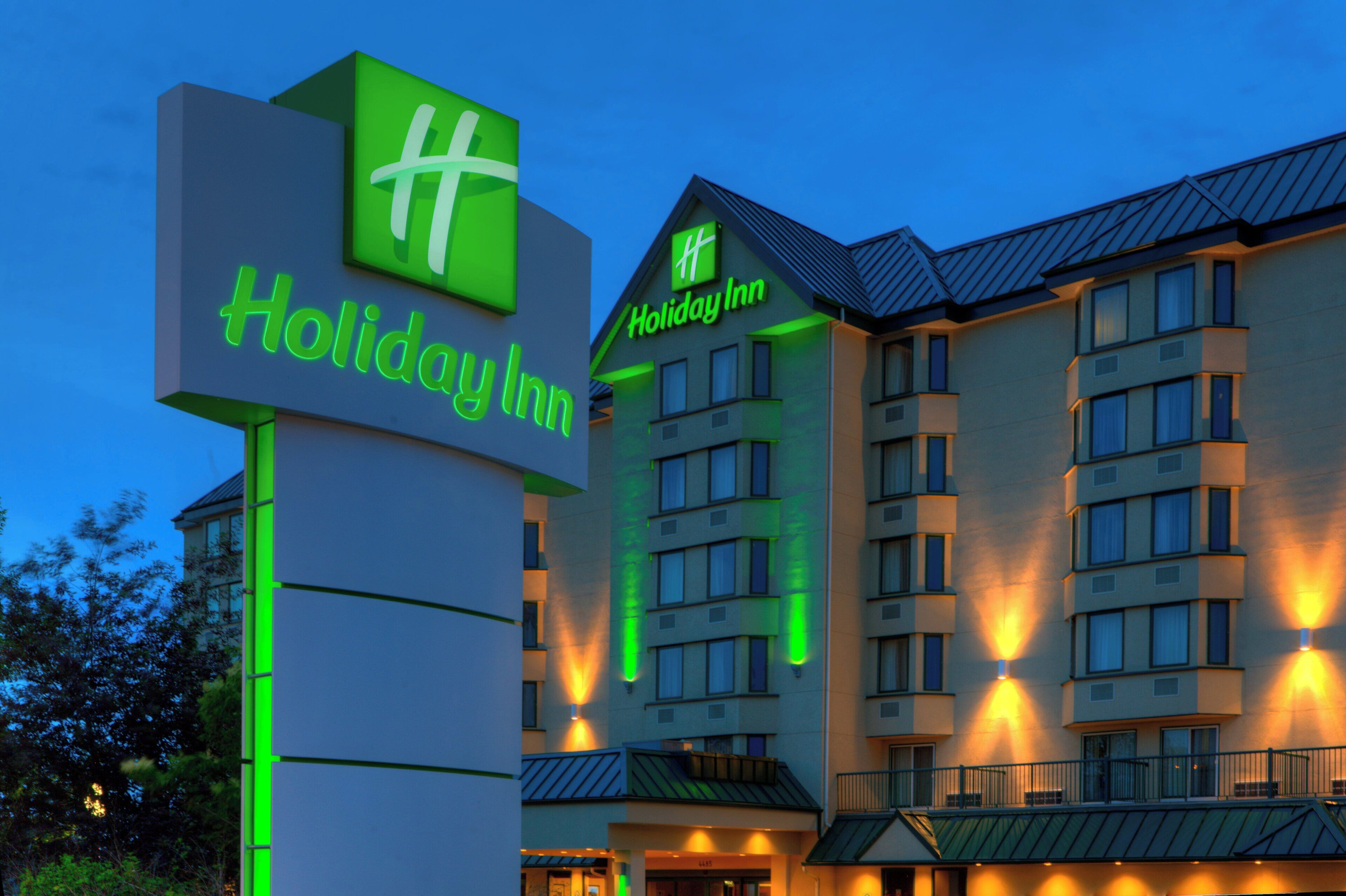 A Holiday Inn hotel sign with a modern design, featuring a prominent logo and the name of the hotel.