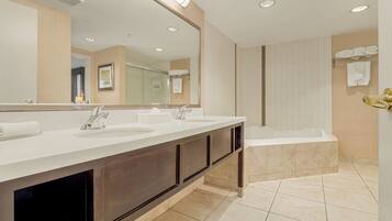 Une salle de bain moderne avec un meuble-lavabo à deux vasques, un grand miroir, une baignoire et un espace douche.
