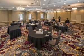 Conference room with high ceilings, ornate chandeliers, and large windows.