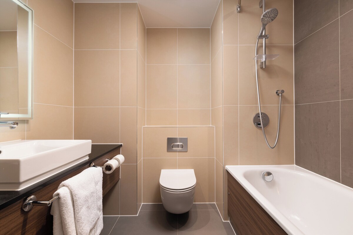 Une salle de bain moderne avec un lavabo, des toilettes et une baignoire.