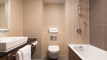 Un baño moderno con lavamanos, inodoro y bañera blancos.