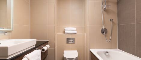 A modern bathroom with a white sink, toilet, and bathtub.