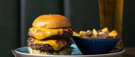 Ein Burger mit Käse und Pommes auf einem Teller.