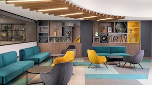 A modern lounge area with sofas, armchairs, and a coffee table.