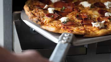 A pizza with pepperoni and cheese on a metal tray.