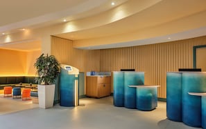 A modern reception area with a seating area, a reception desk, and a large plant.