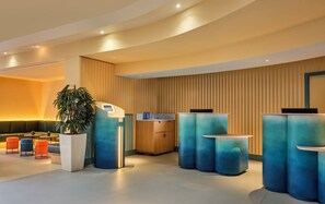 A modern reception area with a seating area, a reception desk, and a large plant. - lyf Chelsea London (London)
