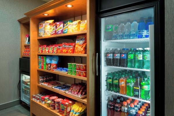 A snack and beverage display with various chips, candies, and sodas.