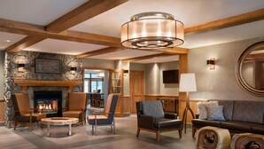 A spacious living room with a fireplace, comfortable seating, and a large mirror.