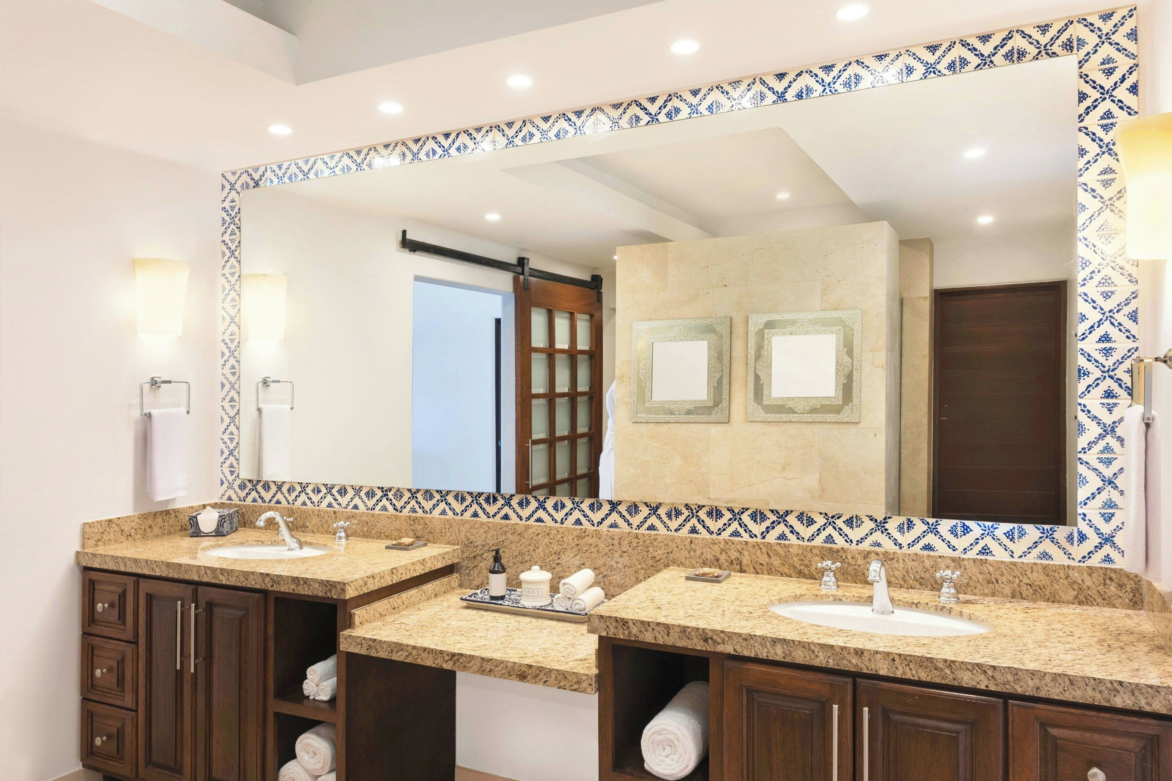 A bathroom with two sinks, a large mirror, and a towel rack.