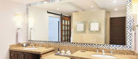 A bathroom with two sinks, a large mirror, and a towel rack.