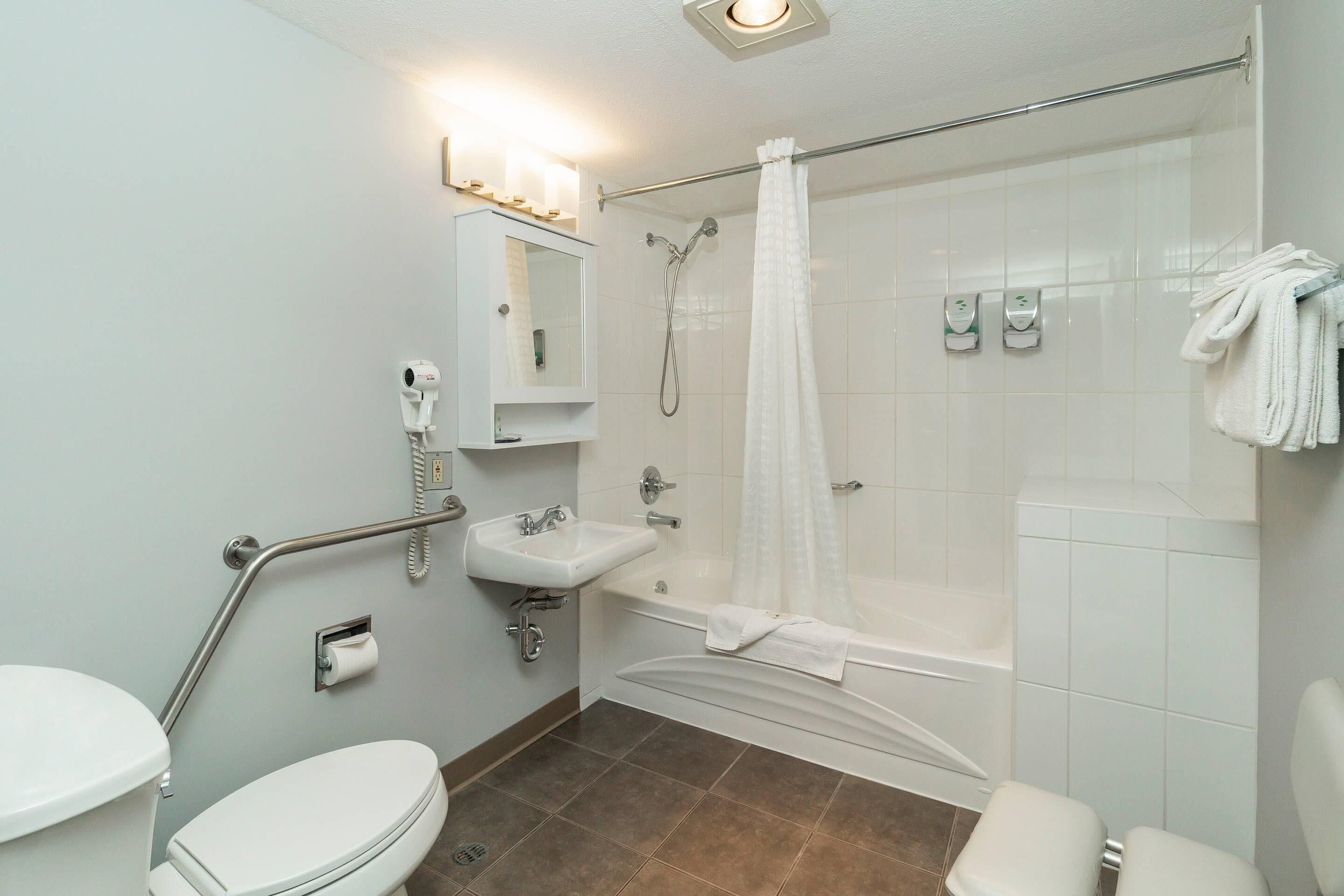 Un baño con inodoro, lavabo, ducha y bañera.