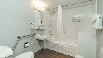 A bathroom with a toilet, sink, shower, and bathtub.