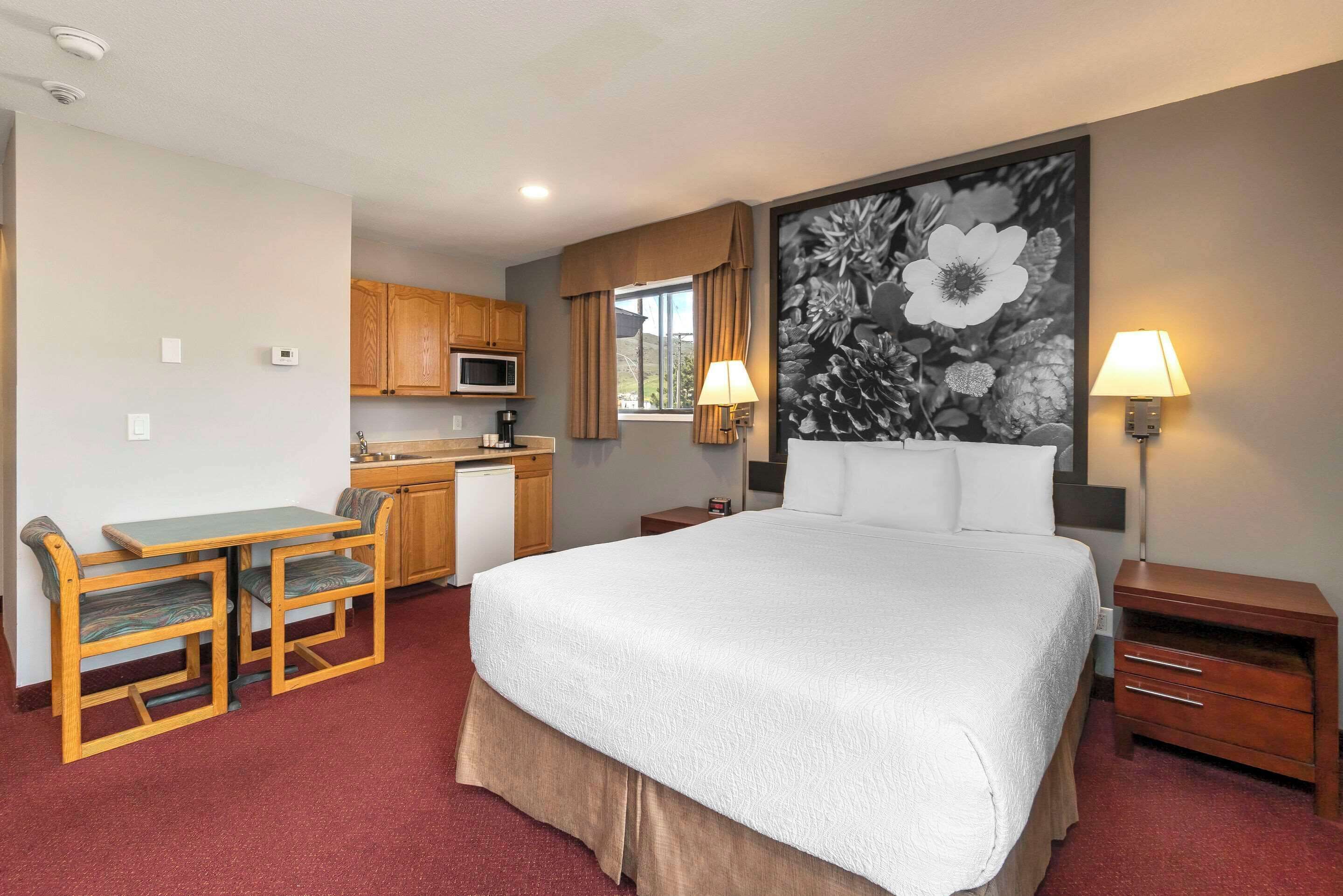 Escritorio, cortinas opacas, tabla de planchar con plancha