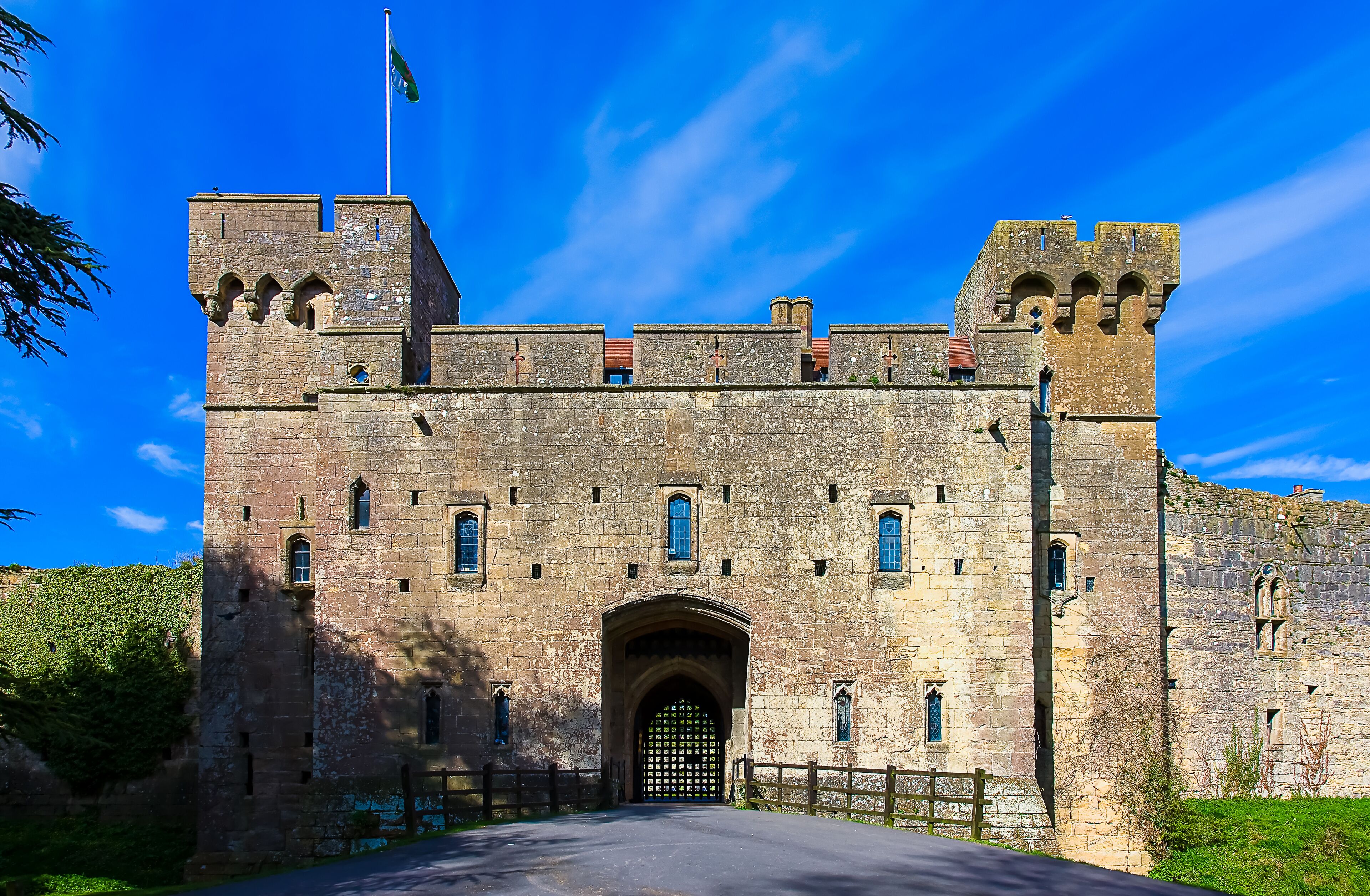 Un château de pierre historique, doté d’une entrée centrale en arc de cercle, de cr éneaux et d’un mât.