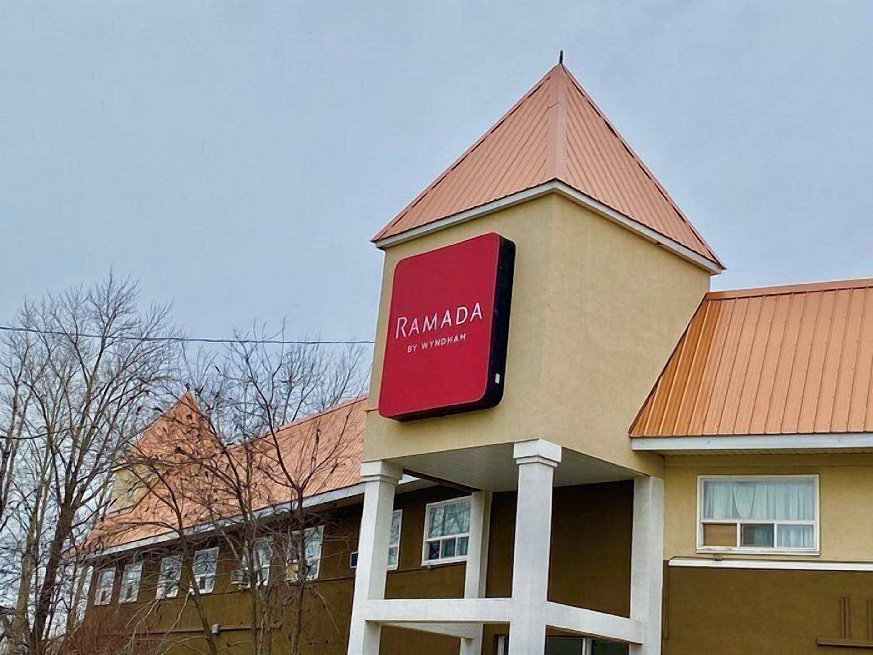 A building with a sign that reads 'RAMADA BY WYNDHAM.'