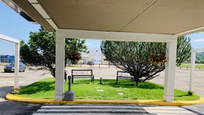 A covered outdoor area with a crosswalk leading to a parking lot. - Ramada by Wyndham Whitecourt (Whitecourt)