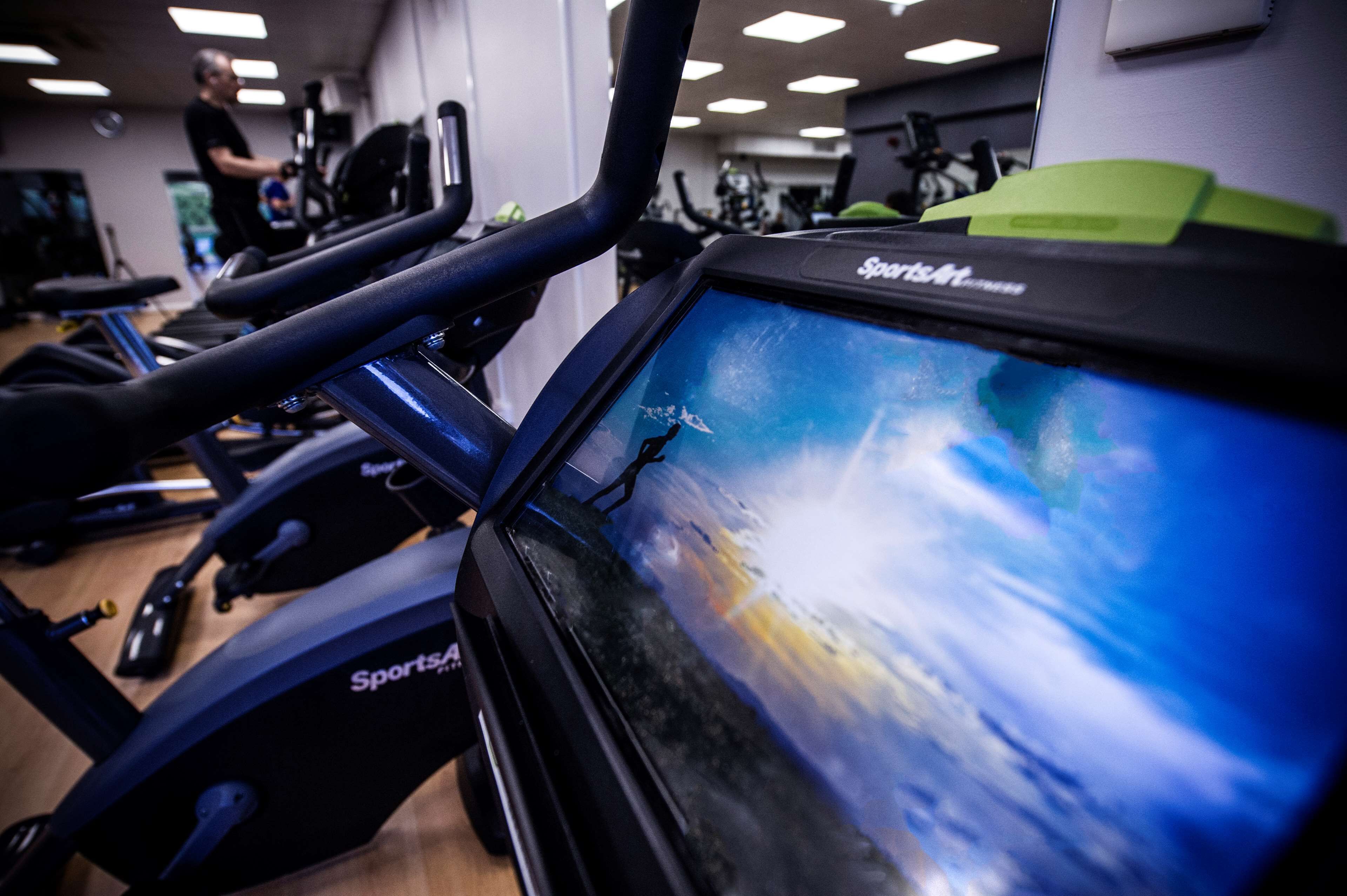 A gym with stationary bikes and a treadmill.