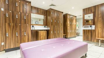 Een moderne badkamer met houten kastjes, een bankje en een opbergruimte voor toiletartikelen.