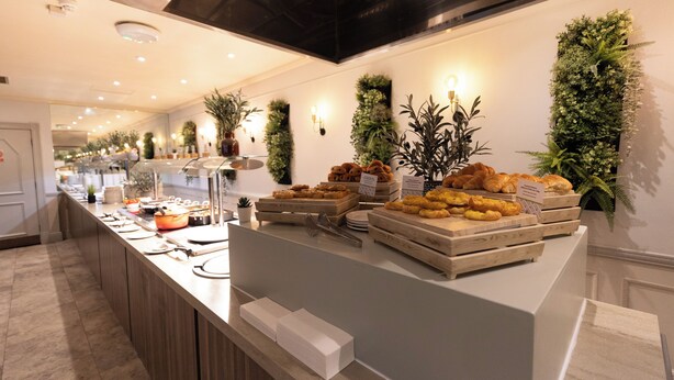 Un buffet proposant une variété de plats, dans un décor intérieur propre et moderne.