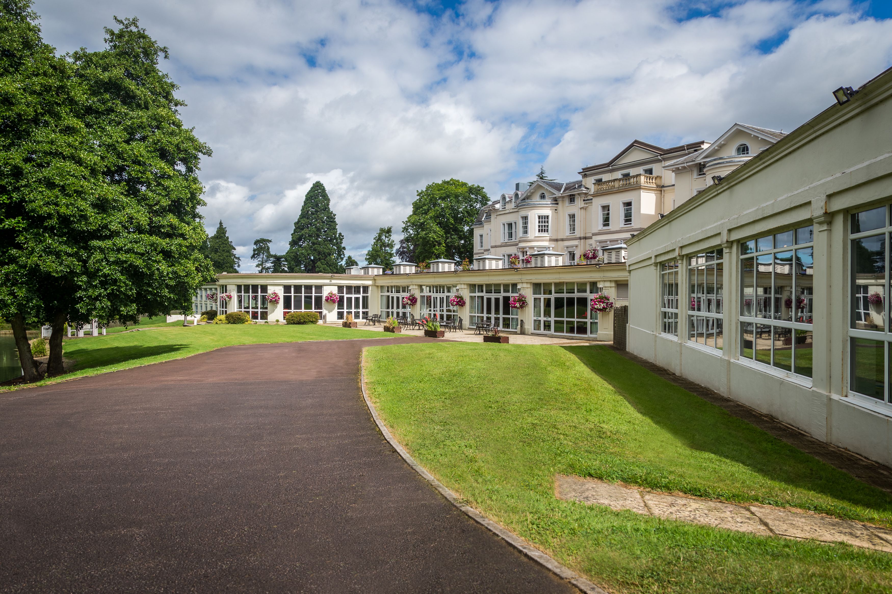 A large, modern building with a spacious driveway and well-maintained lawn.