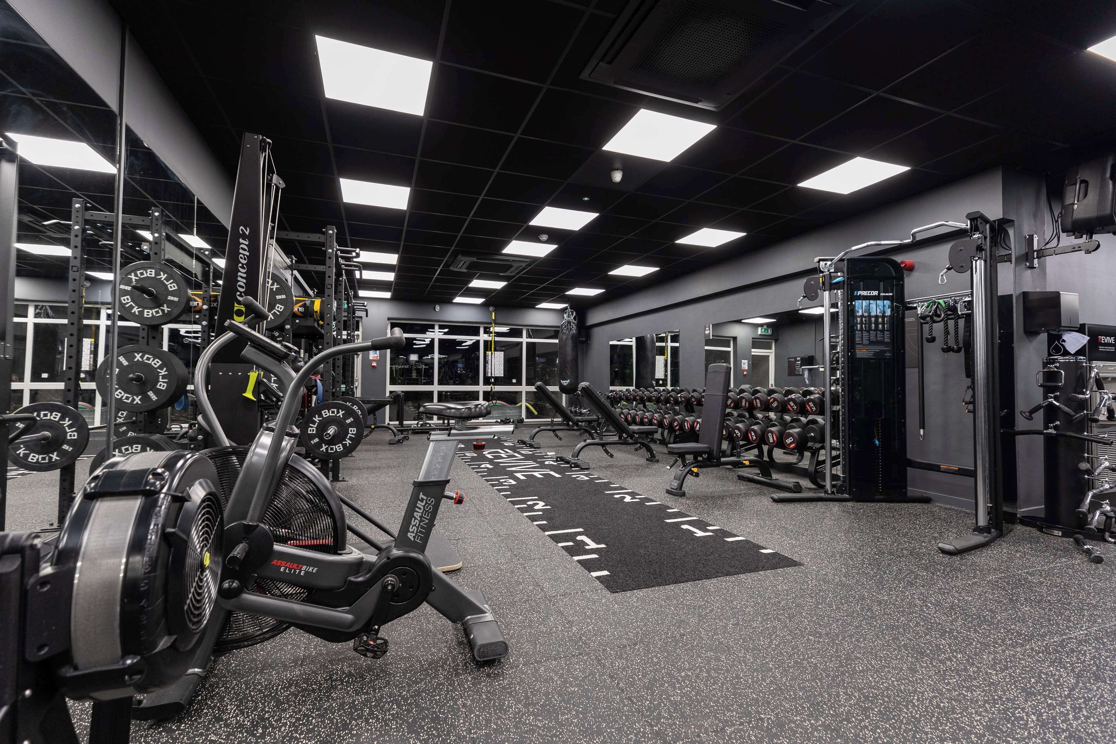 A gym with various exercise equipment, including treadmills, weight machines, and free weights.