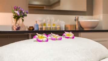 Ein Badezimmer mit einem weißen Handtuch, einer Schale und Flaschen auf der Ablagefläche.
