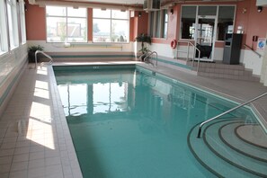 Una piscina techada, sillones reclinables de piscina