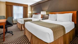 A hotel room with two beds, a desk, a chair, and a window with curtains. - Best Western Strathmore Inn (Strathmore)