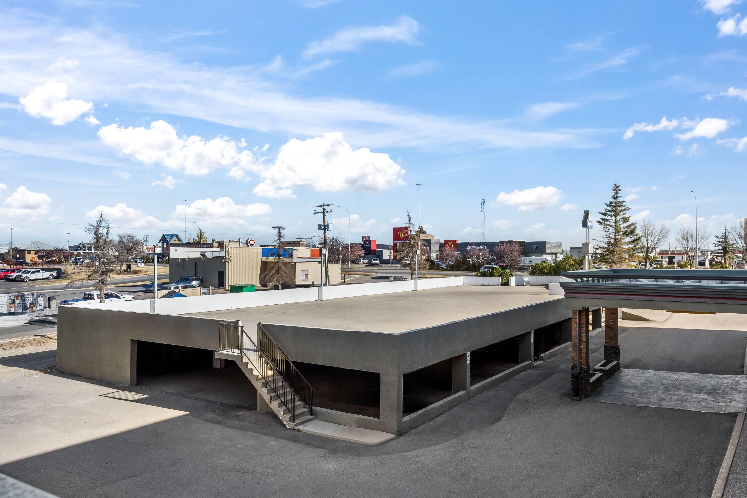 A parking structure with a covered area and a staircase leading to an upper level.