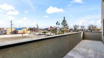 A balcony with a view of a commercial area, including a McDonald's and a DAPPLIN sign.