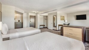 A hotel room with two beds, a desk, a television, and a wardrobe. - Days Inn by Wyndham Airdrie (Airdrie)
