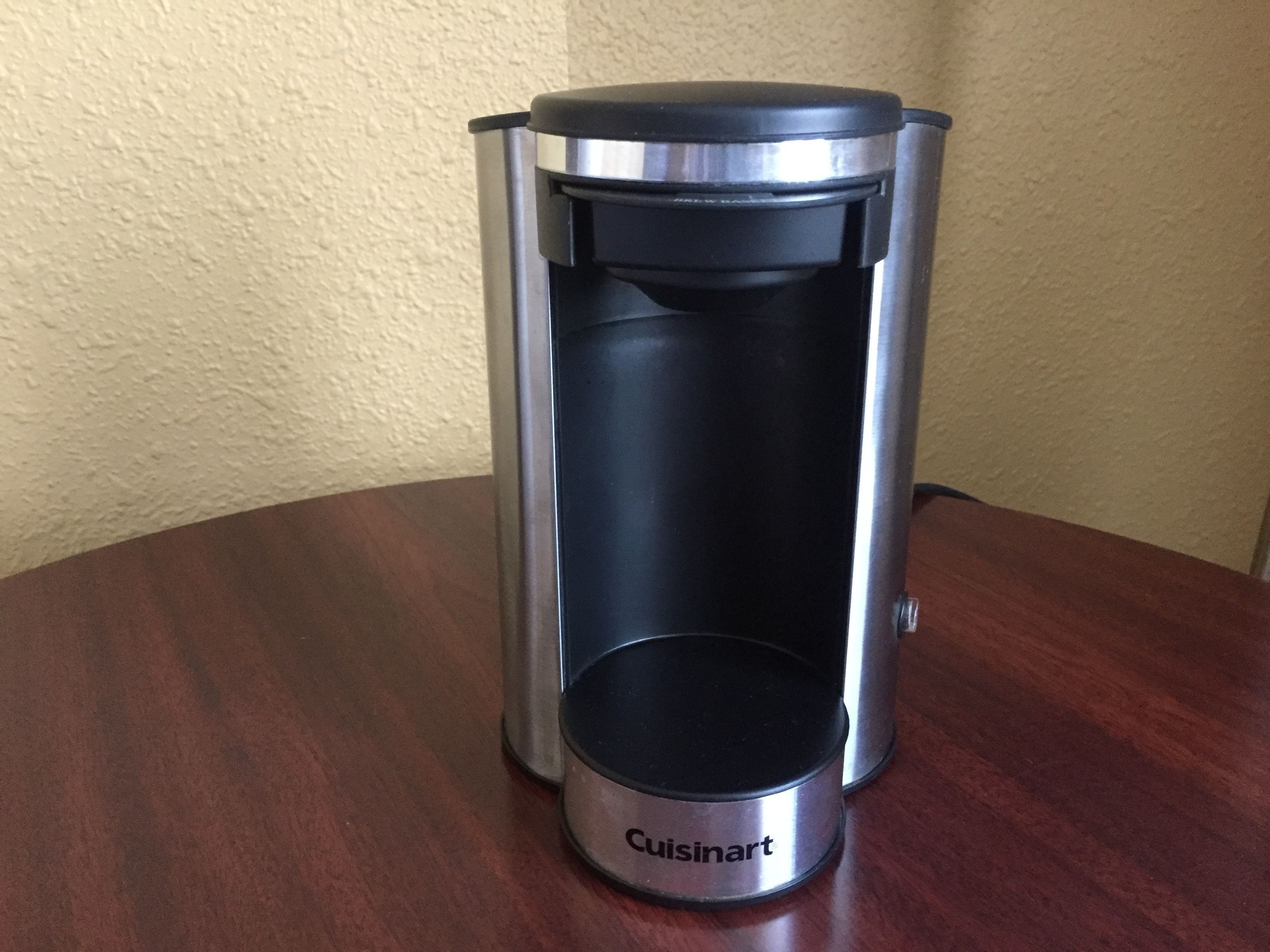 A Cuisinart coffee maker on a wooden table.
