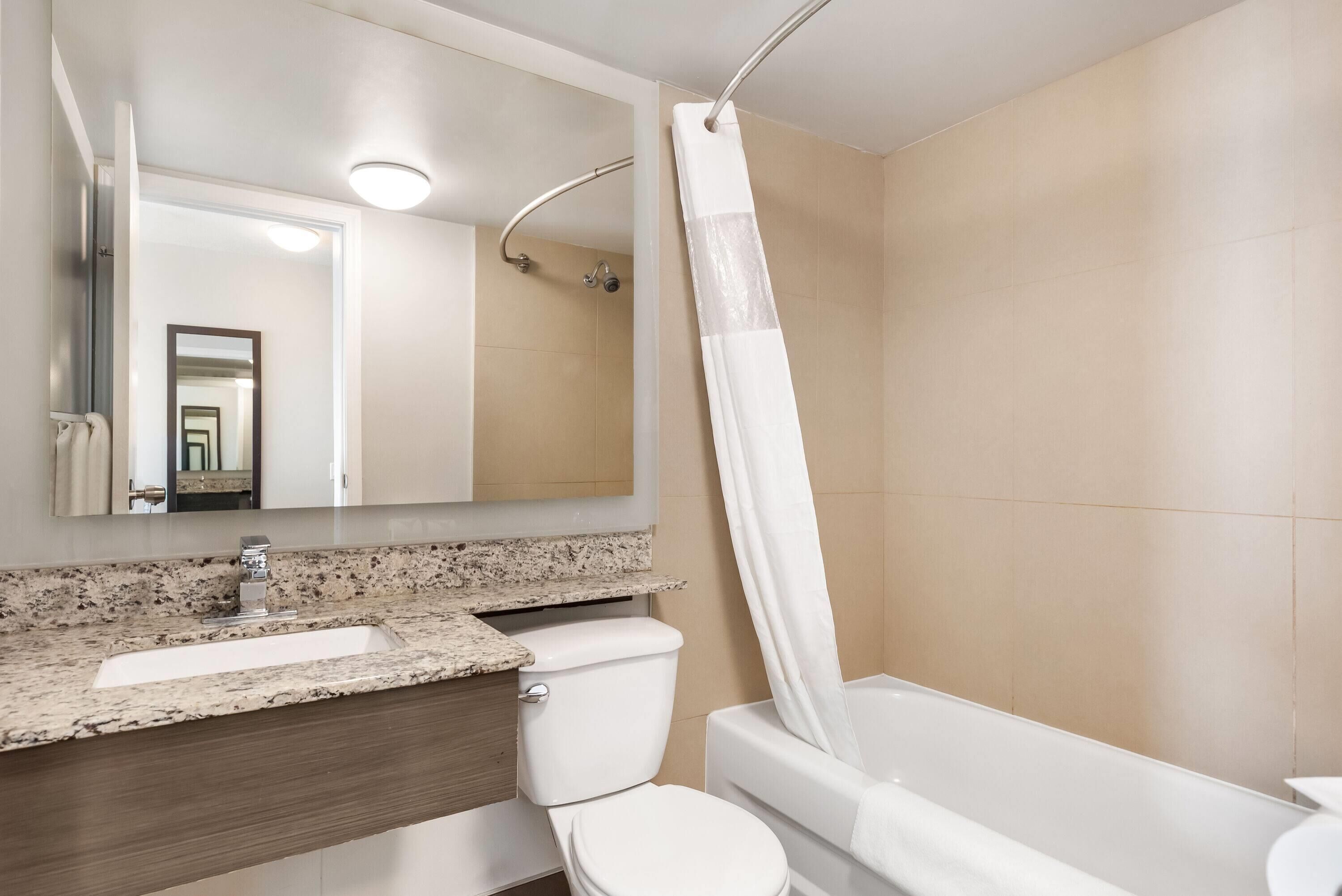 A bathroom with a sink, toilet, and bathtub.